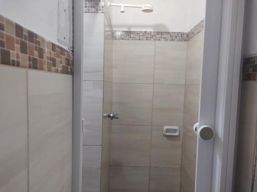 y baño con ducha y puerta de cristal. en Casa encantadora em João pessoa, en João Pessoa