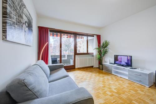 a living room with a couch and a tv at Top Of The Spots - Happy Rentals in Lugano