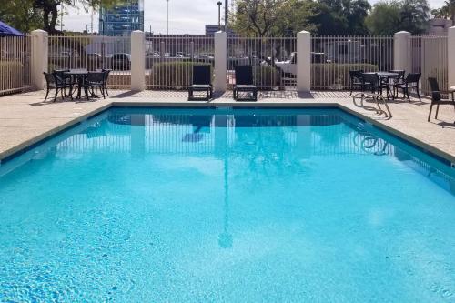 a large blue swimming pool with chairs and tables at Comfort Inn & Suites Tempe Phoenix Sky Harbor Airport in Tempe