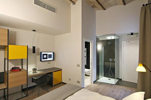 a bedroom with a bed and a desk with a computer at Hotel Giolli Nazionale in Rome