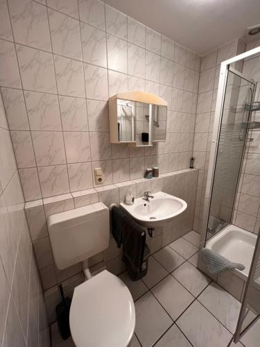 łazienka z toaletą, umywalką i wanną w obiekcie Landhaus Spickermann w mieście Xanten