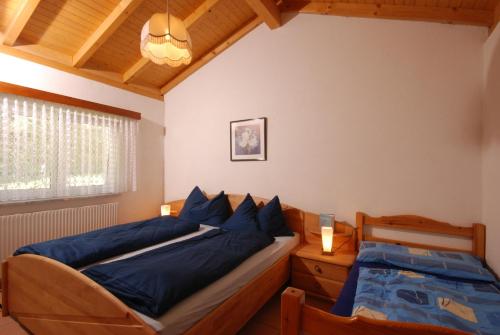 a bedroom with two beds with blue pillows at Casa Esmeralda in San Nazzaro
