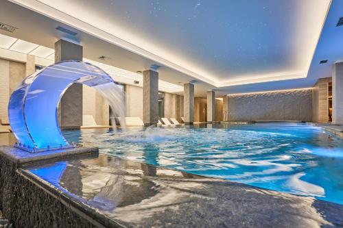 a pool in a hotel with a water fountain at Fomich Apartments in Bukovel