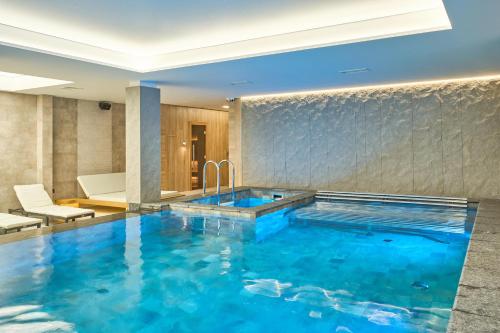 una piscina in una camera d'albergo con una grande vasca blu di Fomich Residence a Bukovel