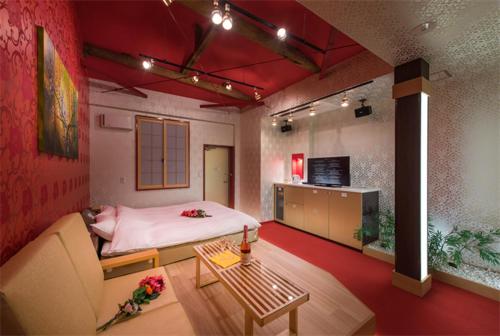 八王子市にあるホテル 鳳凰 大人専用のベッド、ソファ、テーブルが備わる客室です。