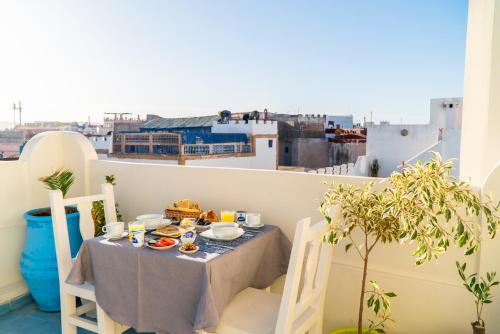 una mesa con comida en el balcón con vistas en ArtHouse Cinema Hotel, en Essaouira