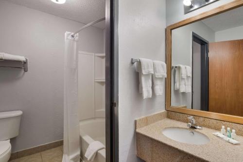 a bathroom with a sink and a toilet and a mirror at Quality Inn in Alice