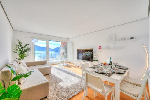 ein Wohnzimmer mit einem Tisch und einem Sofa in der Unterkunft Honeymoon with Stunning View - Happy.Rentals in Castagnola