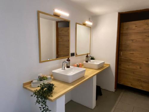 a bathroom with two sinks and a mirror at Omar Hotel & Suites in Torba
