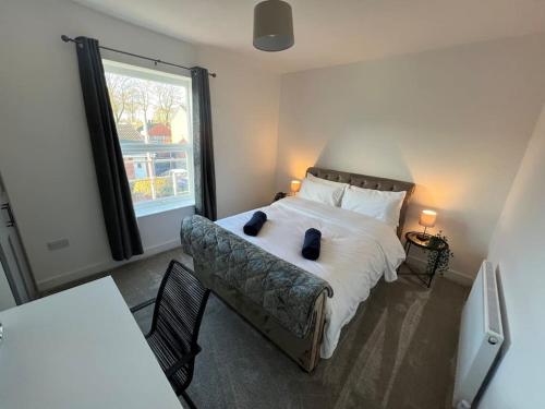 a bedroom with a bed with two pillows and a window at Stylish newly renovated home near Manchester City Centre in Radcliffe