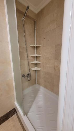 a walk in shower with shelves in a bathroom at Santa Margarita-Fincas Benidorm in Benidorm