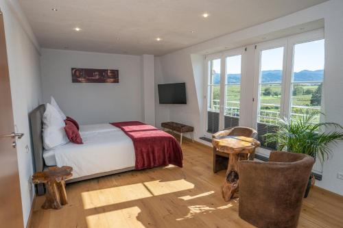 a bedroom with a bed and a large window at Privatweingut Schmidt in Heitersheim