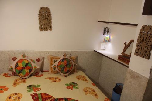 a bedroom with a bed with a comforter on it at Castle View Haveli in Jodhpur