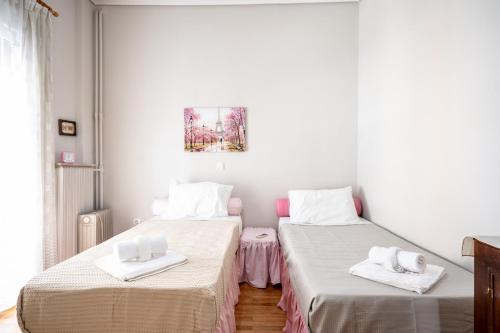 2 letti in una camera con pareti bianche di Family apartment at Kalithea 2 bedrooms 4 pers ad Atene