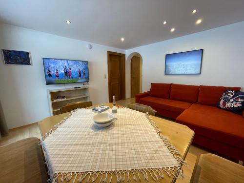 a living room with a red couch and a table at Landhaus Zillertal in Ramsau im Zillertal