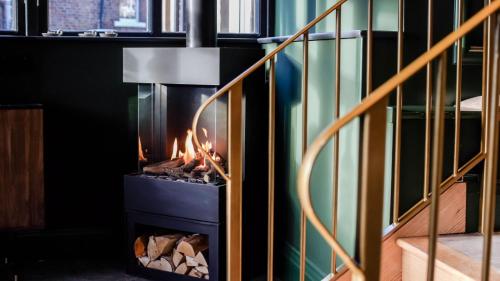 a fireplace in a living room next to a staircase at The Funky Monk in Durham