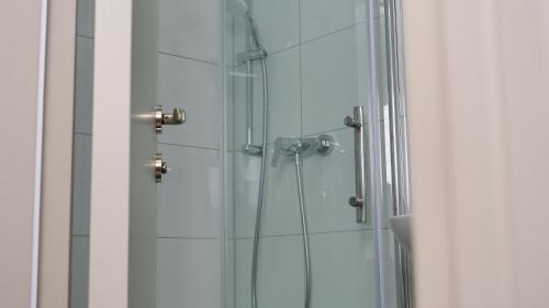 a glass shower in a bathroom with a glass door at Evsenn Hotel in Reutlingen