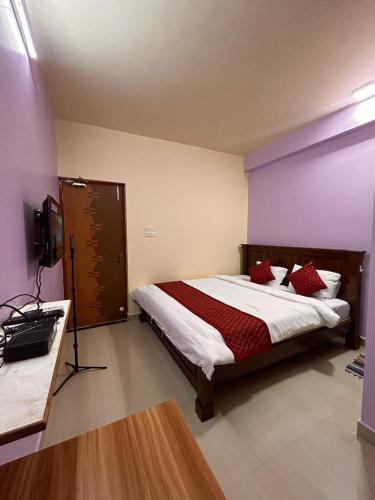 a bedroom with a large bed with red pillows at SAHAY VILLA RESORT in Durbate