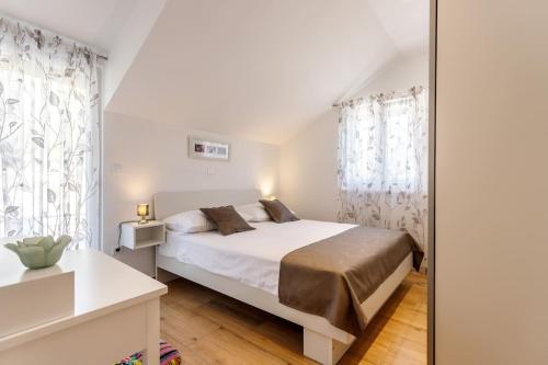 een witte slaapkamer met een bed en een spiegel bij Villa in Omiš inland/4 stars+heated pool in Nova Sela