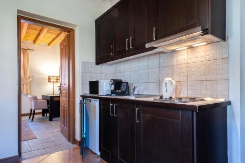 uma cozinha com armários de madeira escura e um lavatório em Lively Lofts by The Varos Residences em Város