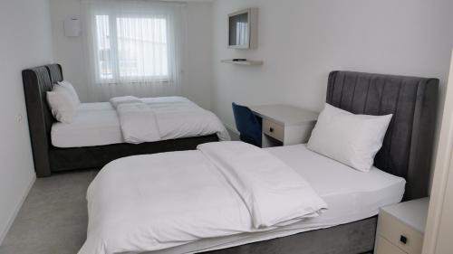 a room with two beds and a desk and a bed at Evsenn Hotel in Reutlingen