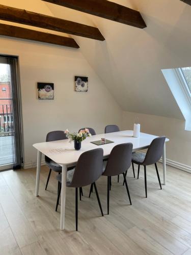 a dining room with a white table and chairs at Hilmor's Lejligheder in Viborg