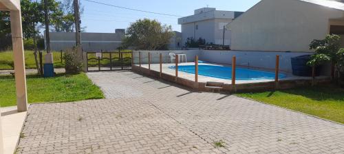 una piscina en un patio junto a una casa en casa a uma quadra do mar, en Torres