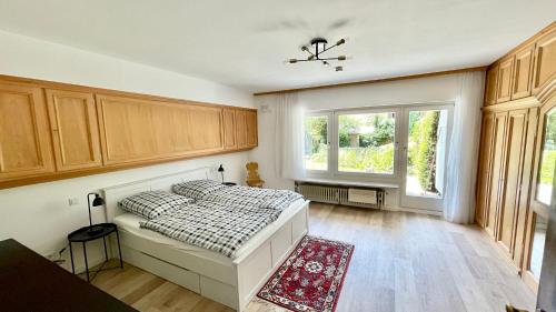 Schlafzimmer mit einem Bett und einem Fenster in der Unterkunft Large holiday apartment with sauna, terrace, garden and open fireplace in Lenggries