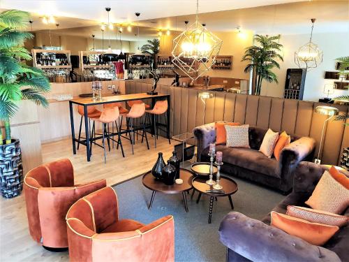 - un salon avec un canapé, des tables et des chaises dans l'établissement Quinta da Palmeira - Country House Retreat & Spa, à Cerdeira