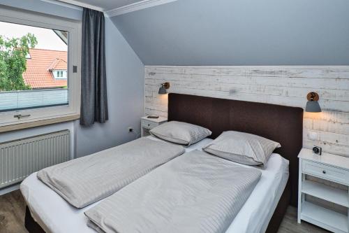 1 dormitorio con 2 camas y ventana en Haus Mühlentrift Döse en Cuxhaven