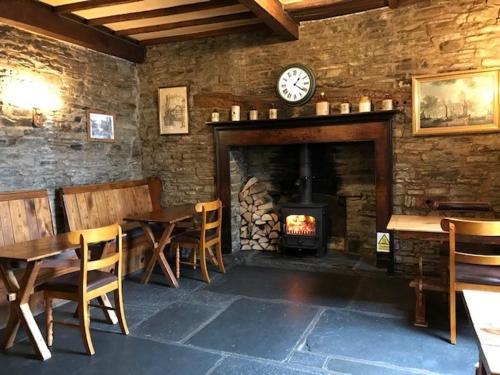 a restaurant with a fireplace and tables and a clock at Castle Inn in Knighton