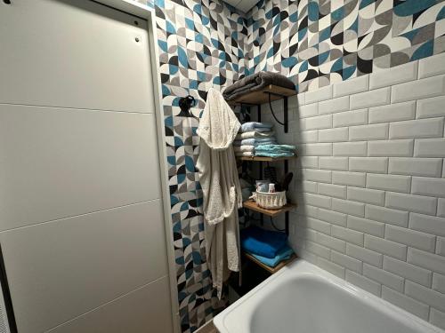a bathroom with a tub and a sink and a tile wall at Villa les Buissonets in Berck-sur-Mer