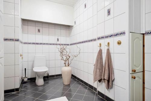 łazienka z toaletą i wazą z kwiatami w obiekcie Adorable 1-bedroom apartment with a fantastic view - Free Parking w mieście Trondheim