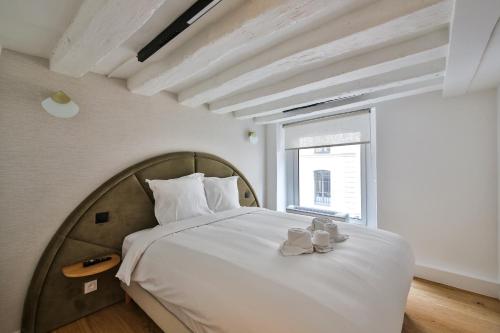 une chambre avec un grand lit blanc avec une fenêtre dans l'établissement 11.Appart 8Pers#Madeleine#Gallerie La Fayette, à Paris