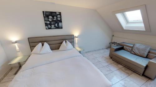 a bedroom with a large white bed and a couch at VISIONAPARTMENTS Binzmühlestrasse 46 - contactless check-in in Zürich