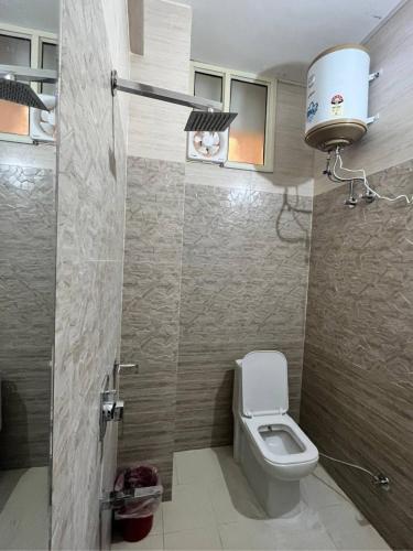 a small bathroom with a toilet and a light at Hotel Shanti Residency in Katra