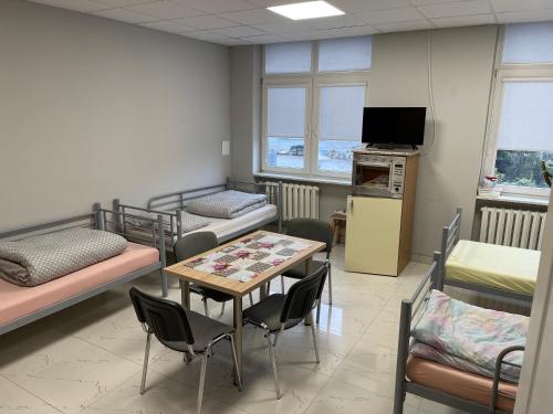 a room with bunk beds and a table and chairs at Hostel ELDORADO in Końskie