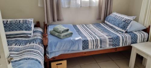 two twin beds in a bedroom with towels on them at Relax in Witsand