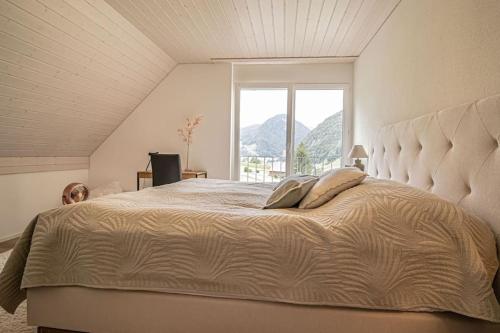 a bedroom with a large bed with a large window at New Chalet with breathtaking views! in Alt Sankt Johann