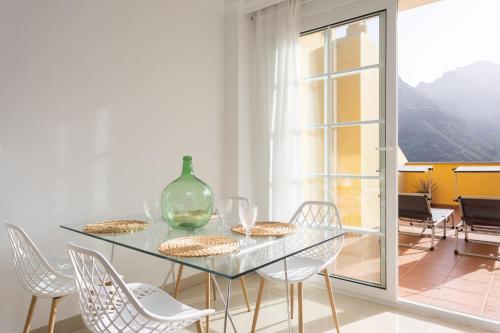 une salle à manger avec une table et des chaises en verre dans l'établissement Home2Book Amazing Views Dúplex Dos Hermanos, à Punta del Hidalgo