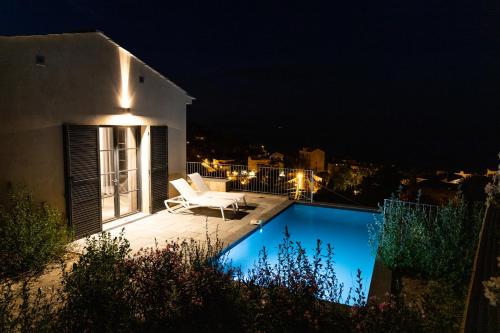une villa avec une piscine la nuit dans l'établissement Villa HUGO, Neuve, 8 pers, pisc chauffée,, à Brando