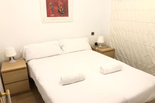 a bedroom with two beds with white sheets and two lamps at NEW! Apartment in Sarria near Metro in Barcelona