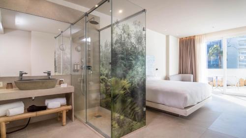 baño con ducha, cama y lavamanos en Cádiz Bahía by QHotels, en Cádiz