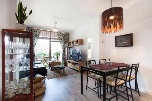 una sala da pranzo con tavolo e sedie e un soggiorno di Cozy Apartment near Fira Gran Via with AC a Hospitalet de Llobregat