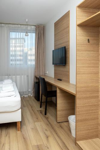 a hotel room with a desk with a bed and a television at Hotel Muli in Reykjavík