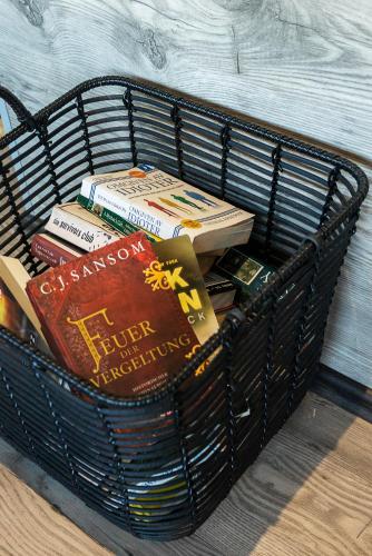 a basket full of books sitting on the floor at Hotel Muli in Reykjavík