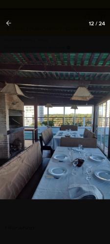 una sala da pranzo con un tavolo con piatti e bicchieri da vino di Excelente y práctico a Punta del Este
