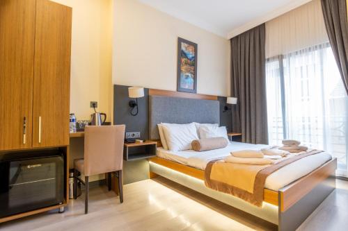 ein Hotelzimmer mit einem Bett, einem Schreibtisch und einem TV in der Unterkunft ORANGE HOTEL & Spa in Istanbul