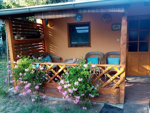 a porch of a house with chairs and flowers at Penzion Slunce nad Vinným Sklepem in Moravská Nová Ves