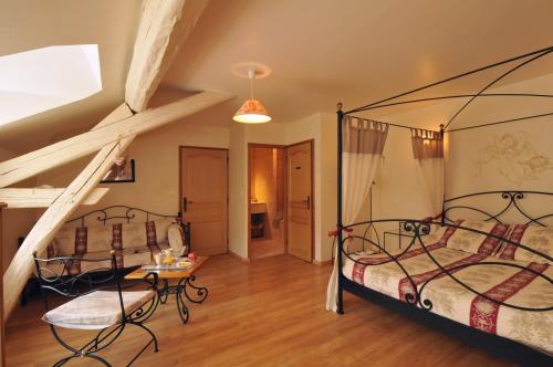 une chambre avec deux lits en fer et un escalier dans l'établissement La Boulonne, à Festigny